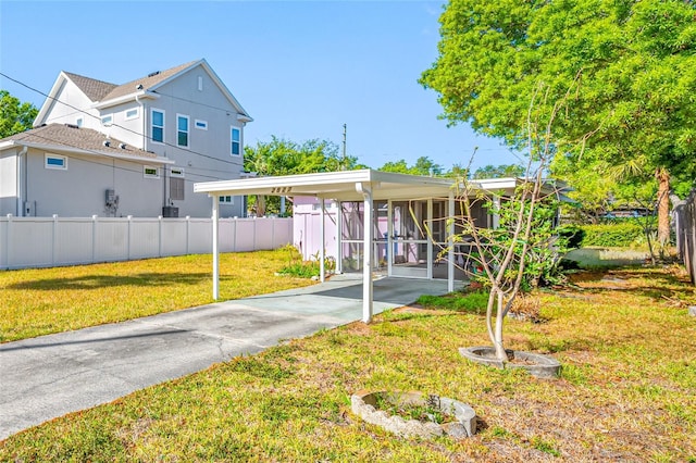 2827 1st St NE, Saint Petersburg, FL 33704 - view of front facade featuring an attached carport, fence, and a front lawn