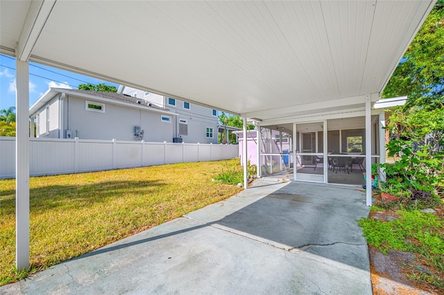 2827 1st St NE, Saint Petersburg, FL 33704 - view of patio / terrace featuring a carport, a sunroom, fence, and concrete driveway