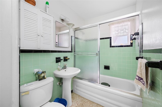 2827 1st St NE, Saint Petersburg, FL 33704 - full bath with toilet, speckled floor, wainscoting, bath / shower combo with glass door, and tile walls