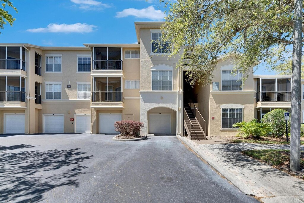 5125 Palm Springs Blvd Unit 6106, Tampa, FL 33647 - view of building exterior featuring driveway, an attached garage, and stairway
