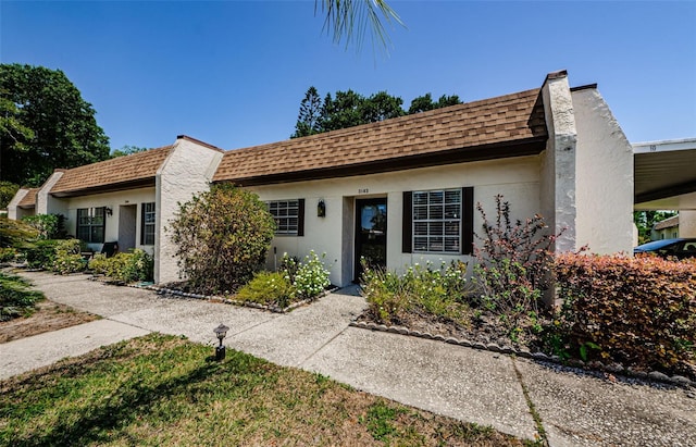 3143 Mission Grove Dr, Palm Harbor, FL 34684 - view of front of home featuring stucco siding and a shingled roof