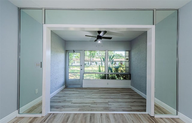 3143 Mission Grove Dr, Palm Harbor, FL 34684 - empty room featuring wood finished floors, ceiling fan, baseboards, and a wealth of natural light