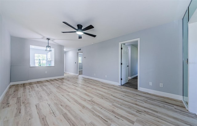 3143 Mission Grove Dr, Palm Harbor, FL 34684 - unfurnished living room featuring light wood-style flooring, baseboards, a ceiling fan, and visible vents