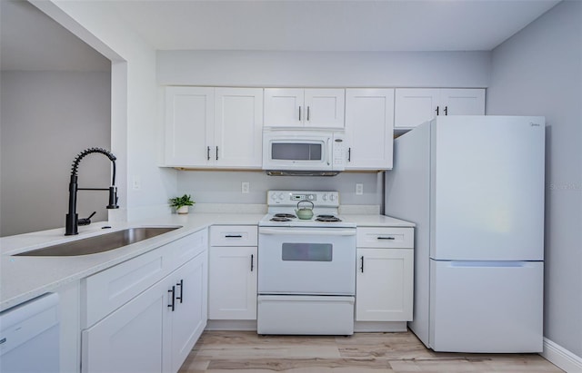 3143 Mission Grove Dr, Palm Harbor, FL 34684 - kitchen with white appliances, white cabinetry, a sink, and light wood finished floors