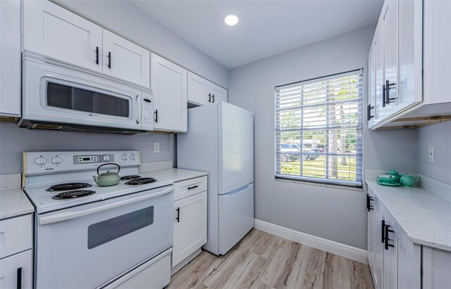 3143 Mission Grove Dr, Palm Harbor, FL 34684 - kitchen featuring white appliances, light wood-style flooring, white cabinetry, recessed lighting, and baseboards