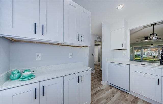 3143 Mission Grove Dr, Palm Harbor, FL 34684 - kitchen with white cabinetry, a ceiling fan, white dishwasher, a sink, and light wood finished floors