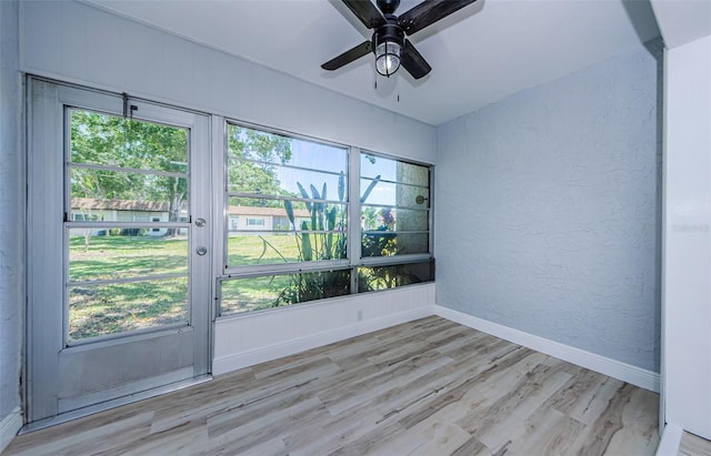 3143 Mission Grove Dr, Palm Harbor, FL 34684 - unfurnished room featuring light wood-style floors, baseboards, a ceiling fan, and a healthy amount of sunlight