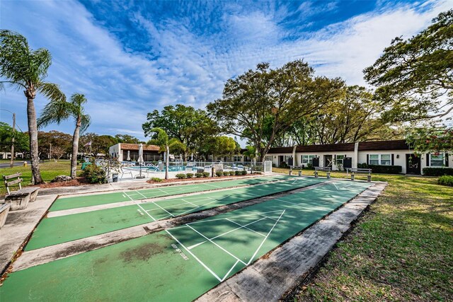 3143 Mission Grove Dr, Palm Harbor, FL 34684 - view of community with a lawn, fence, and shuffleboard