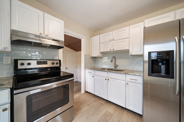 2585 9th Ave N, Saint Petersburg, FL 33713 - kitchen with stainless steel appliances, under cabinet range hood, a sink, light wood-type flooring, and tasteful backsplash