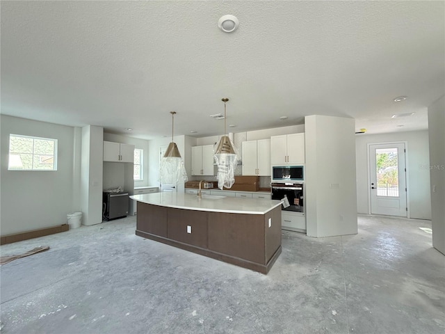 5235 9th Ave N, Saint Petersburg, FL 33710 - kitchen featuring oven, built in microwave, white cabinets, a sink, and concrete floors