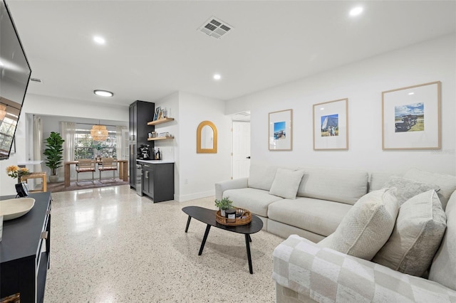 living area featuring light speckled floor, recessed lighting, baseboards, and visible vents