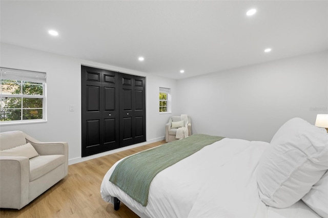 bedroom featuring baseboards, a closet, light wood-style flooring, and recessed lighting