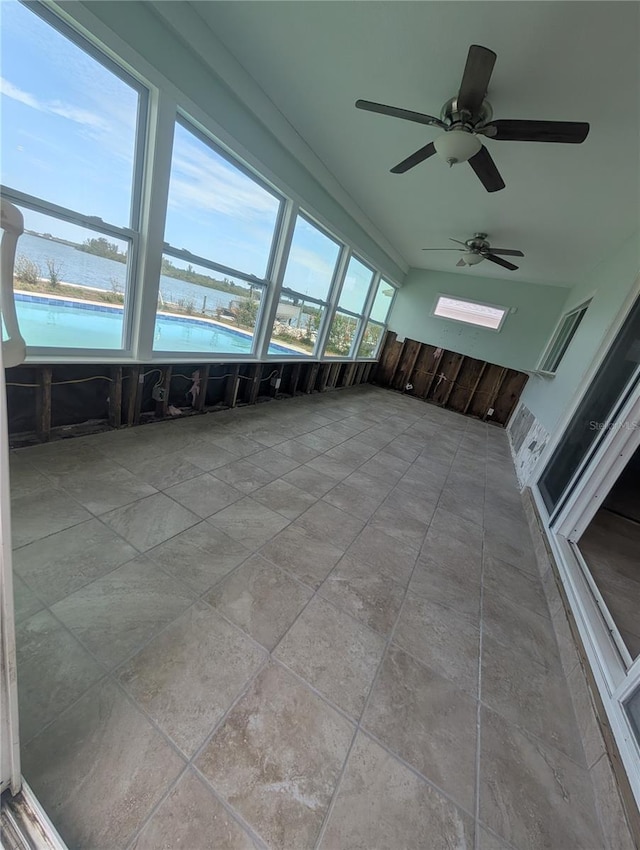 unfurnished sunroom featuring a water view