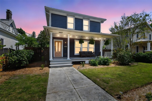 view of front of home featuring ceiling fan, a porch, fence, and a front lawn