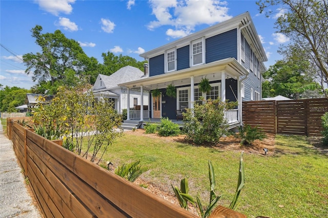 view of front facade featuring fence, a porch, and a front yard