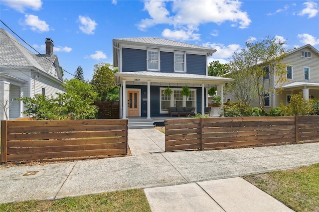 american foursquare style home featuring covered porch, a fenced front yard, and a gate