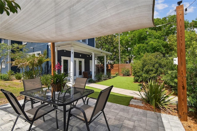 view of patio featuring outdoor dining area and fence