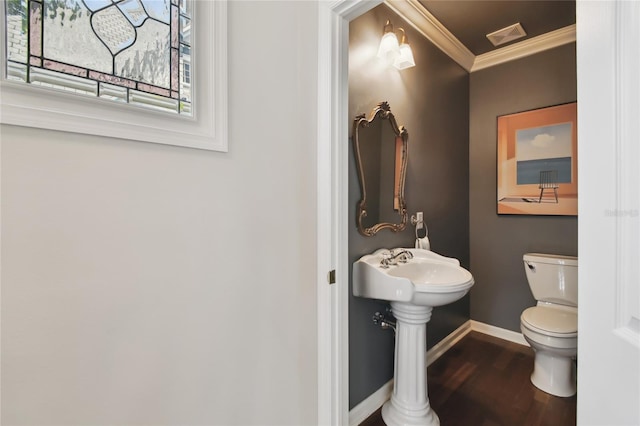 half bathroom featuring visible vents, baseboards, ornamental molding, toilet, and wood finished floors