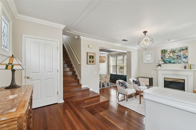 living room featuring visible vents, a glass covered fireplace, stairway, and wood finished floors