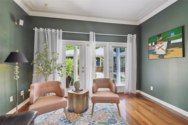 living area featuring french doors, crown molding, baseboards, and wood finished floors