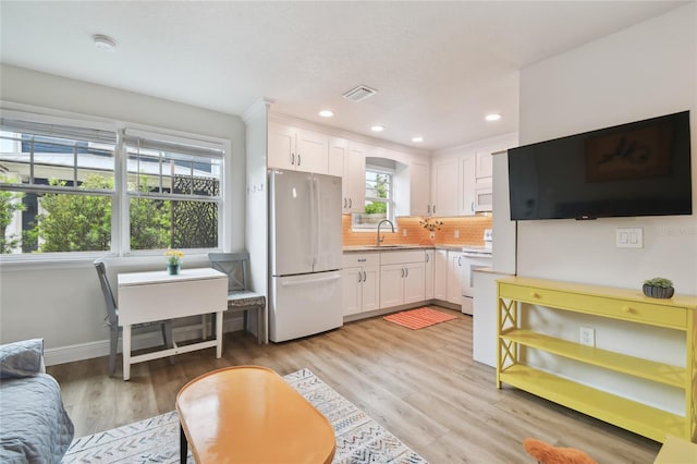 kitchen featuring light countertops, white cabinets, visible vents, and white appliances