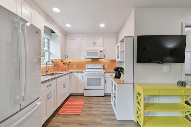 kitchen featuring white cabinetry, a sink, backsplash, and white appliances