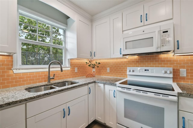 kitchen with white appliances, white cabinetry, backsplash, and a sink