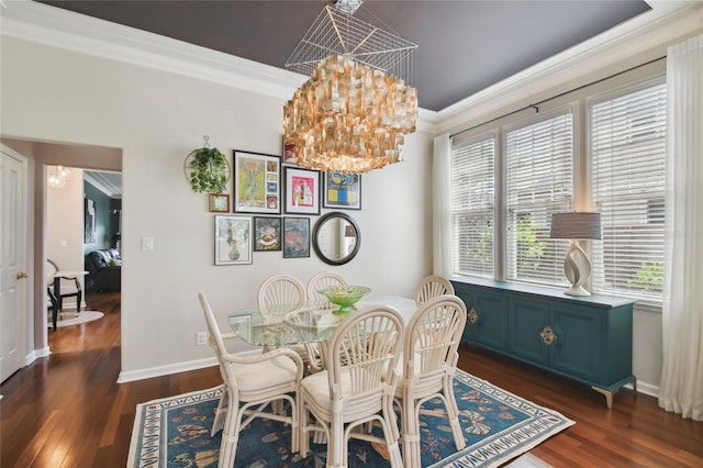 dining room with dark wood-type flooring, baseboards, crown molding, and a notable chandelier