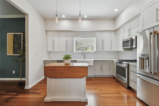 kitchen featuring light countertops, a sink, stainless steel appliances, and wood finished floors