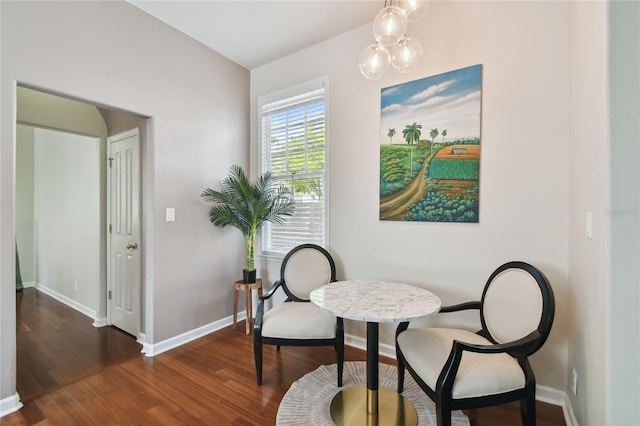sitting room with dark wood-type flooring and baseboards