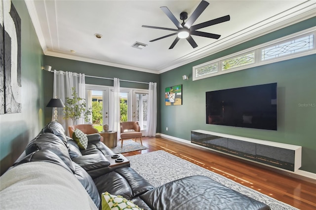 living room with a ceiling fan, wood finished floors, crown molding, and visible vents