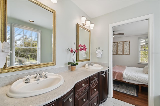 ensuite bathroom featuring double vanity, connected bathroom, a sink, and a ceiling fan