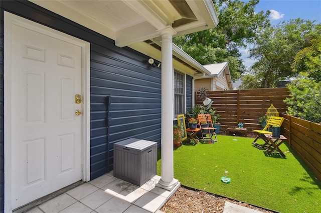 doorway to property with fence and a lawn
