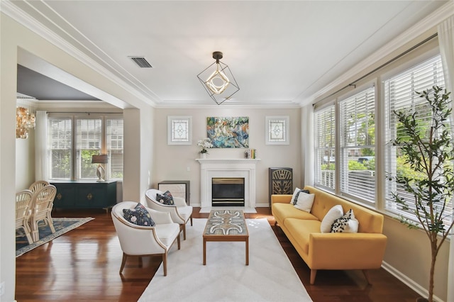 living room with visible vents, crown molding, baseboards, dark wood-style floors, and a glass covered fireplace