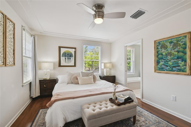 bedroom with baseboards, dark wood finished floors, ensuite bath, ceiling fan, and visible vents