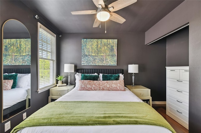 bedroom with dark wood-style floors and a ceiling fan