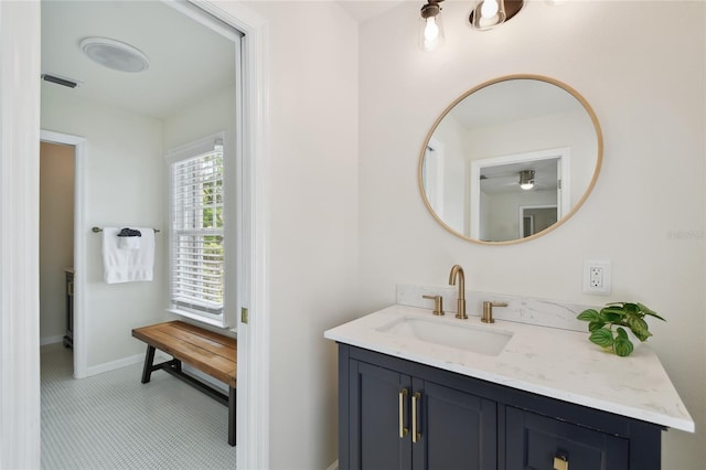 bathroom with baseboards, visible vents, ceiling fan, and vanity