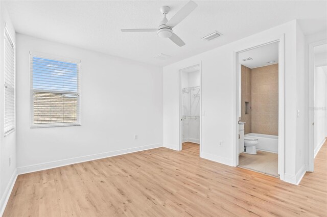 30900 Spruceberry Ct, Wesley Chapel, FL 33543 - unfurnished bedroom with a spacious closet, visible vents, light wood-style flooring, and baseboards