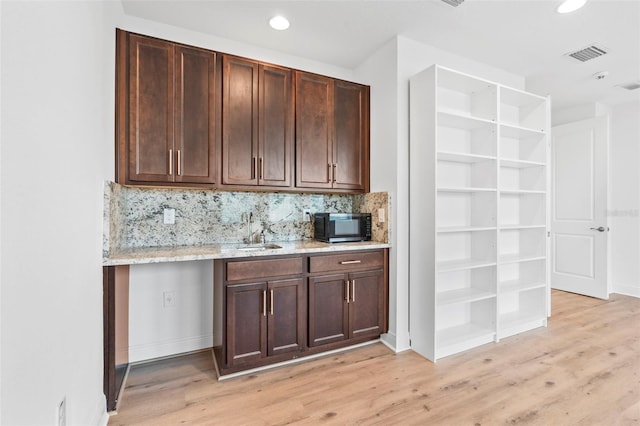 30900 Spruceberry Ct, Wesley Chapel, FL 33543 - bar featuring a sink, visible vents, black microwave, and light wood-style flooring