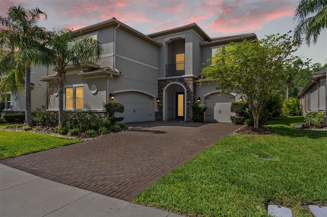 30900 Spruceberry Ct, Wesley Chapel, FL 33543 - mediterranean / spanish-style house with stucco siding, decorative driveway, stone siding, a front lawn, and a garage