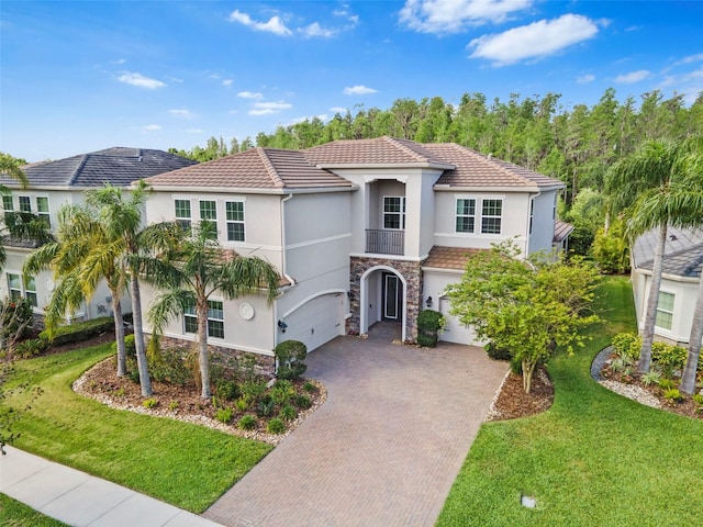 30900 Spruceberry Ct, Wesley Chapel, FL 33543 - mediterranean / spanish house featuring stone siding, a garage, stucco siding, a front lawn, and decorative driveway