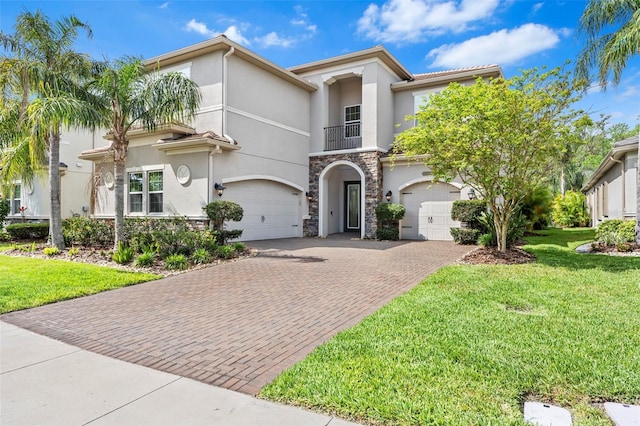 30900 Spruceberry Ct, Wesley Chapel, FL 33543 - mediterranean / spanish-style home featuring stucco siding, stone siding, decorative driveway, a front lawn, and a garage