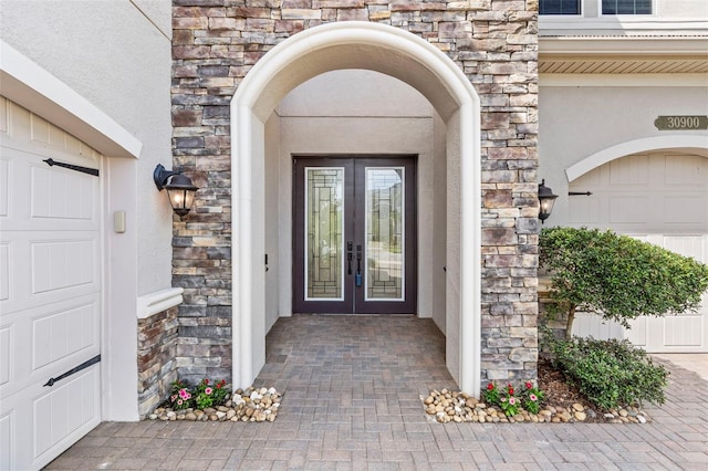 30900 Spruceberry Ct, Wesley Chapel, FL 33543 - entrance to property featuring french doors, stone siding, and a garage