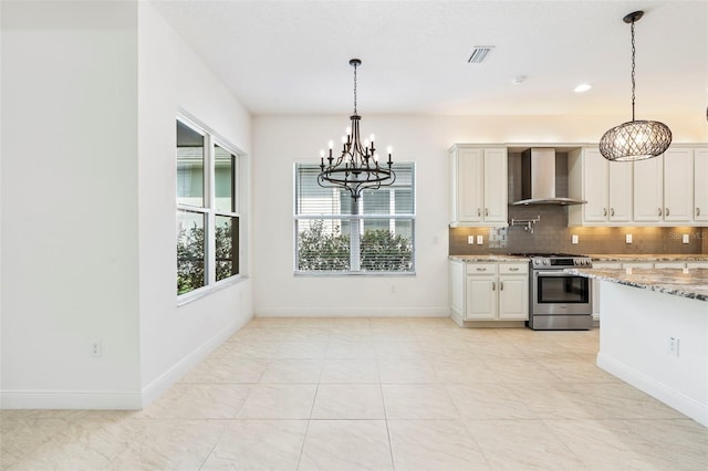 30900 Spruceberry Ct, Wesley Chapel, FL 33543 - kitchen featuring tasteful backsplash, visible vents, wall chimney range hood, a chandelier, and stainless steel gas stove