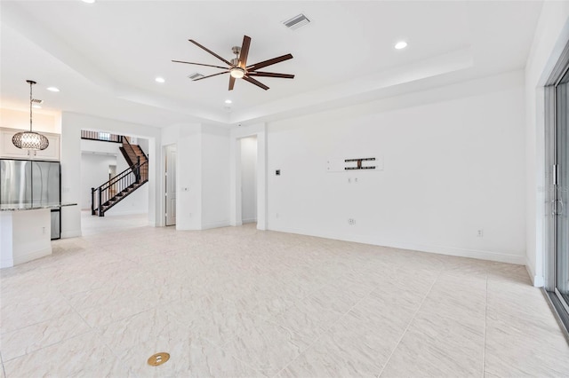 30900 Spruceberry Ct, Wesley Chapel, FL 33543 - unfurnished living room with recessed lighting, stairway, visible vents, and a tray ceiling