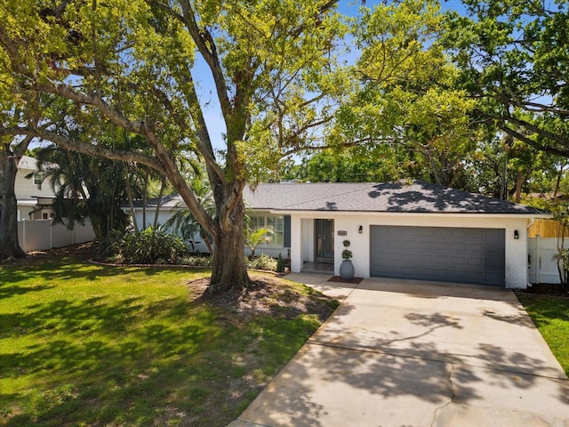 1666 N Dakota Ave NE, Saint Petersburg, FL 33703 - single story home featuring fence, an attached garage, concrete driveway, a front yard, and brick siding