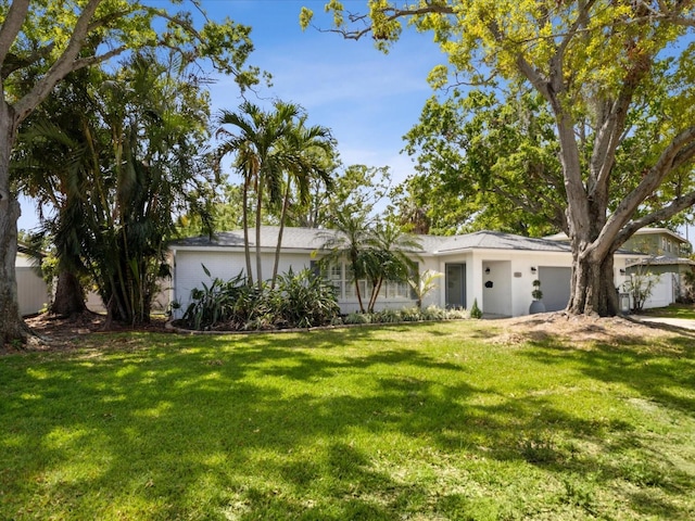 1666 N Dakota Ave NE, Saint Petersburg, FL 33703 - view of front of home featuring a front yard, an attached garage, and stucco siding