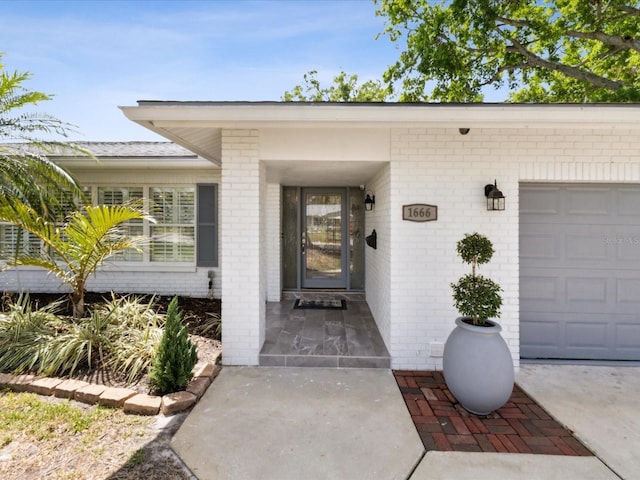 1666 N Dakota Ave NE, Saint Petersburg, FL 33703 - doorway to property with brick siding and an attached garage
