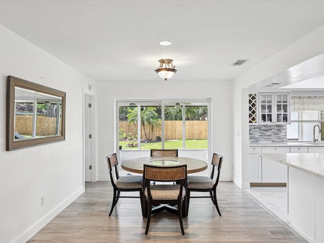 1666 N Dakota Ave NE, Saint Petersburg, FL 33703 - dining area with light wood-type flooring, baseboards, and visible vents