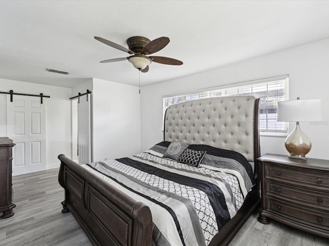 1666 N Dakota Ave NE, Saint Petersburg, FL 33703 - bedroom with light wood-style floors, a barn door, and visible vents